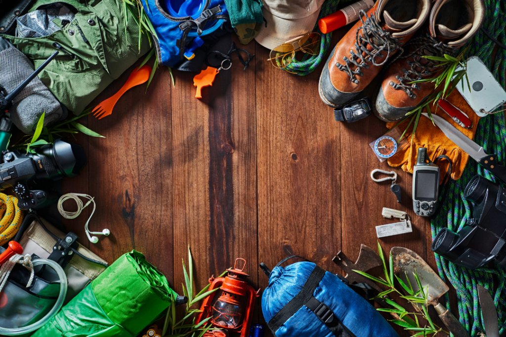 various hiking gear laid out in a circle on a wooden table